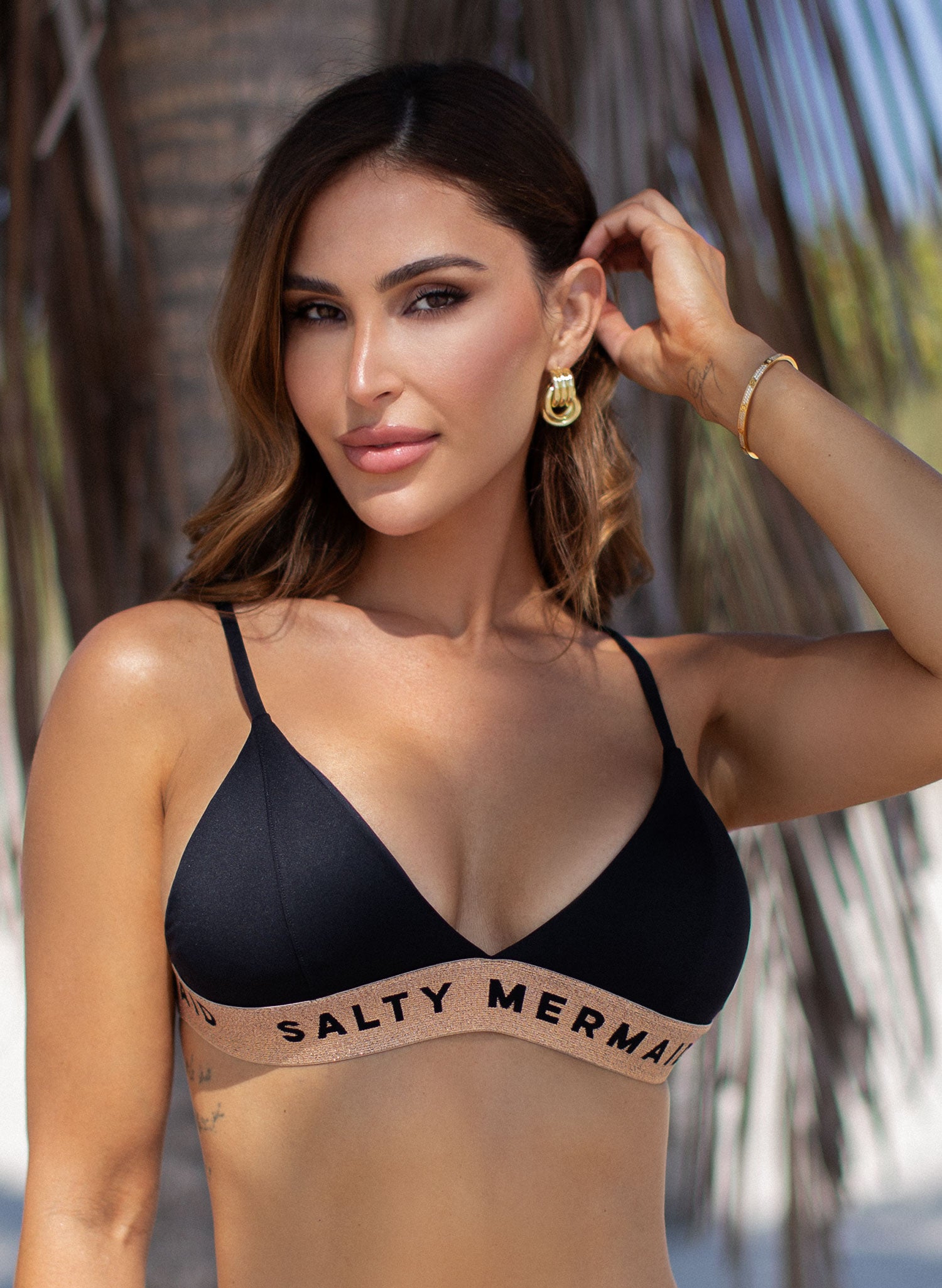 Salty Mermaid signature banded logo bikini in classic Jet Black with rose gold accents, featuring supportive adjustable straps and high-hip semi-cheeky bottoms. Sleek, sporty swimwear with a flattering silhouette—ideal for luxe beachwear and resort-ready style.