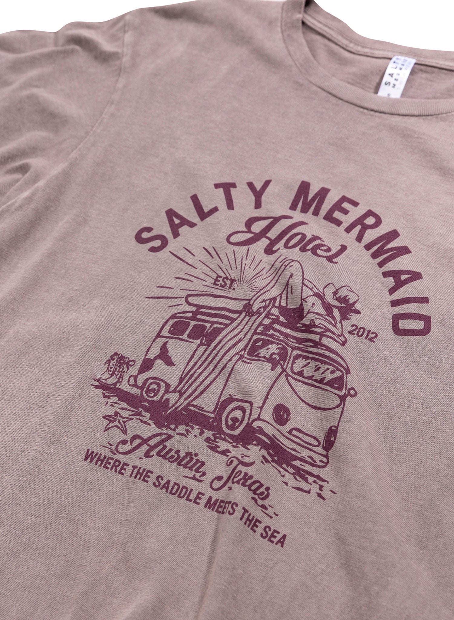 women's mauve acid wash t-shirt with Western style vintage surf graphic 'where saddle meets the sea' by salty mermaid hotel collection.