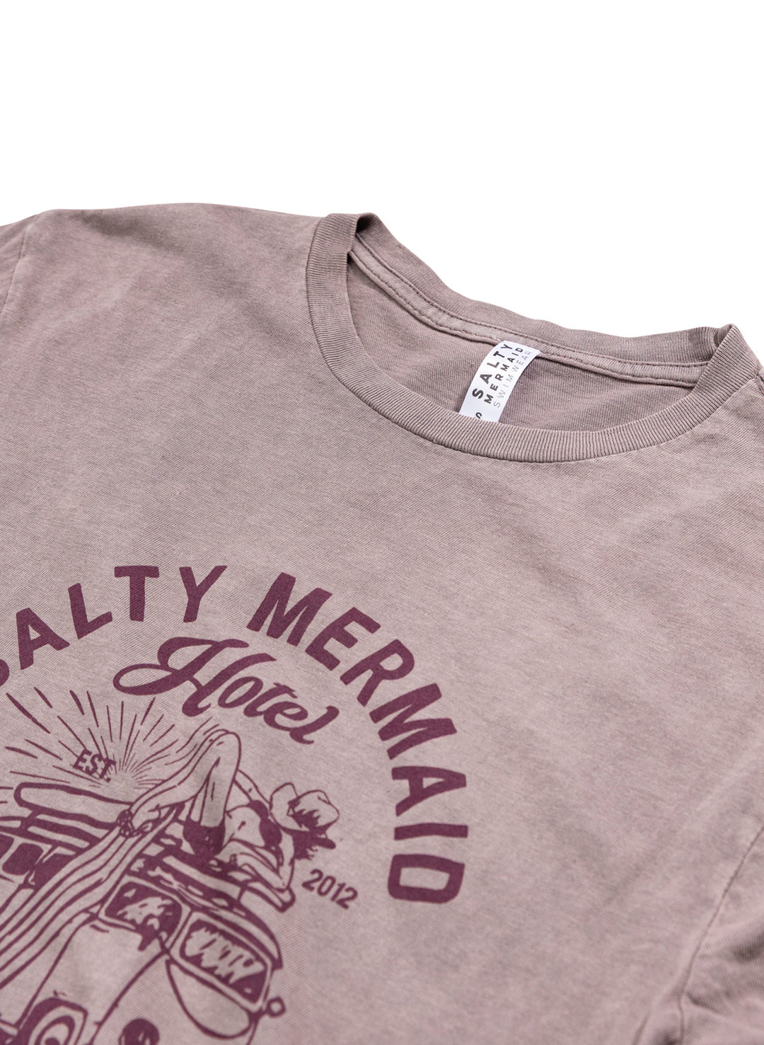 Mauve colored salty mermaid hotel graphic t-shirt close up view with western-inspired surf graphic tee.