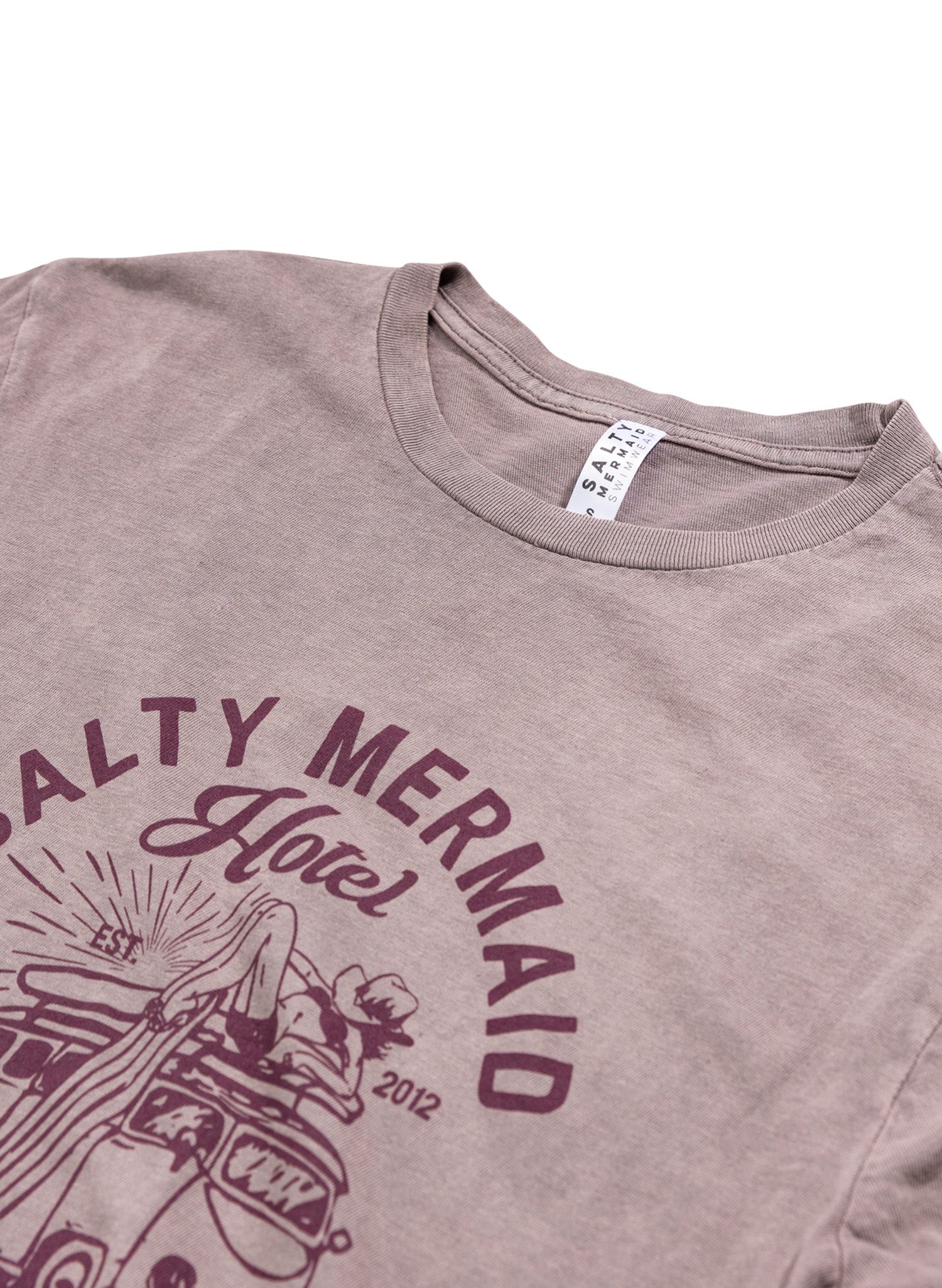 Mauve colored salty mermaid hotel graphic t-shirt close up view with western-inspired surf graphic tee.