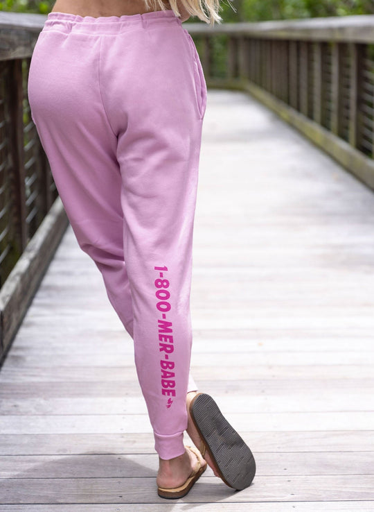 Salty Mermaid pink jogger sweatpants with 1-800-Mer-Babe leg graphic, elastic waistband, and relaxed lounge fit