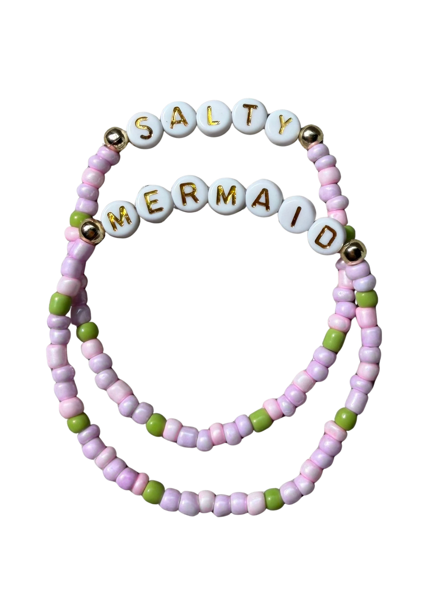 Two beaded stretch bracelets on a white background. One bracelet is white with gold lettering spelling 'SALTY', and the other is white with gold lettering spelling 'MERMAID'.