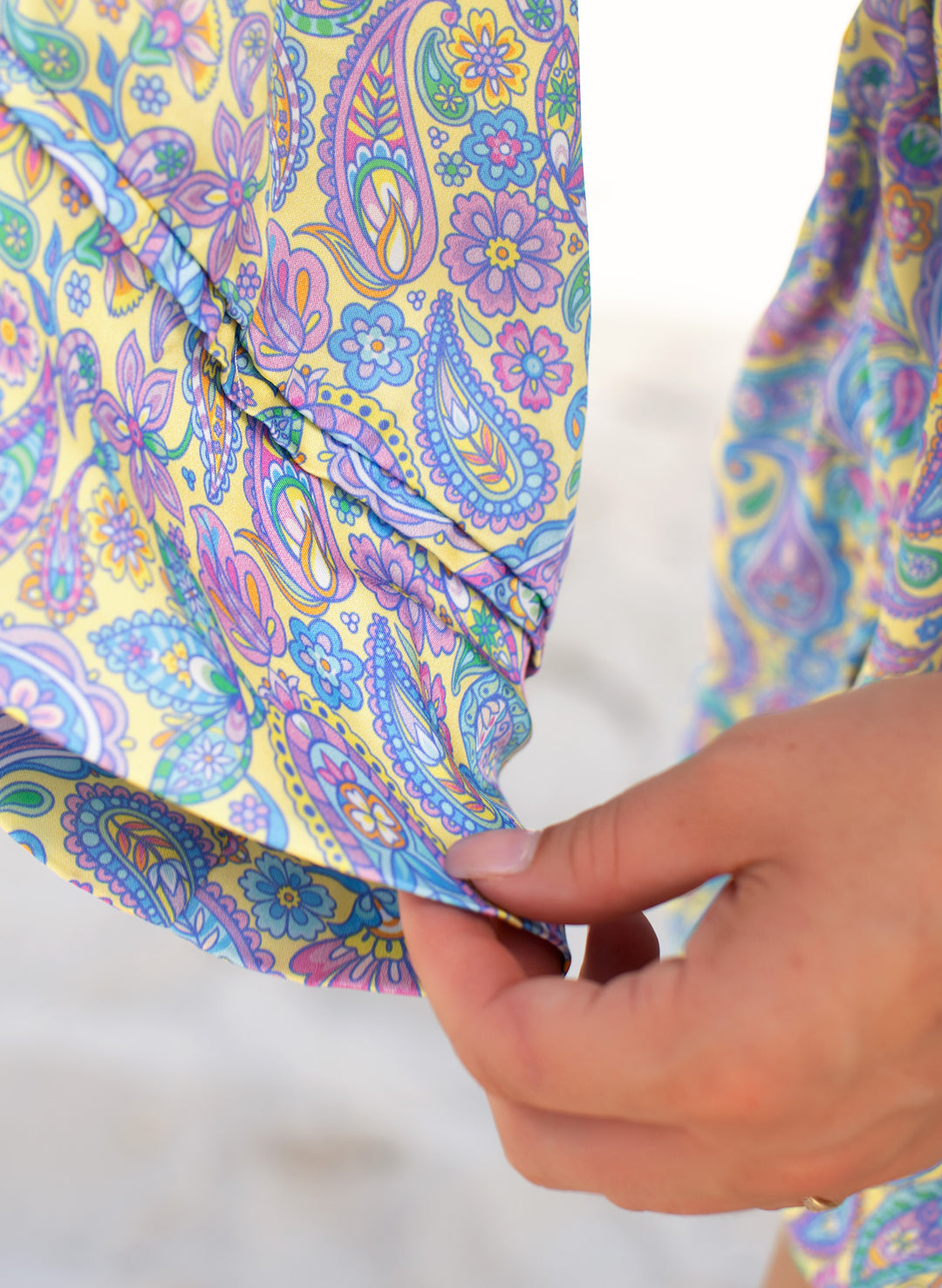 Close-up of Salty Mermaid’s lightweight Sugar Swirl kaftan fabric in a colorful pastel floral paisley print with a flowing drape.
