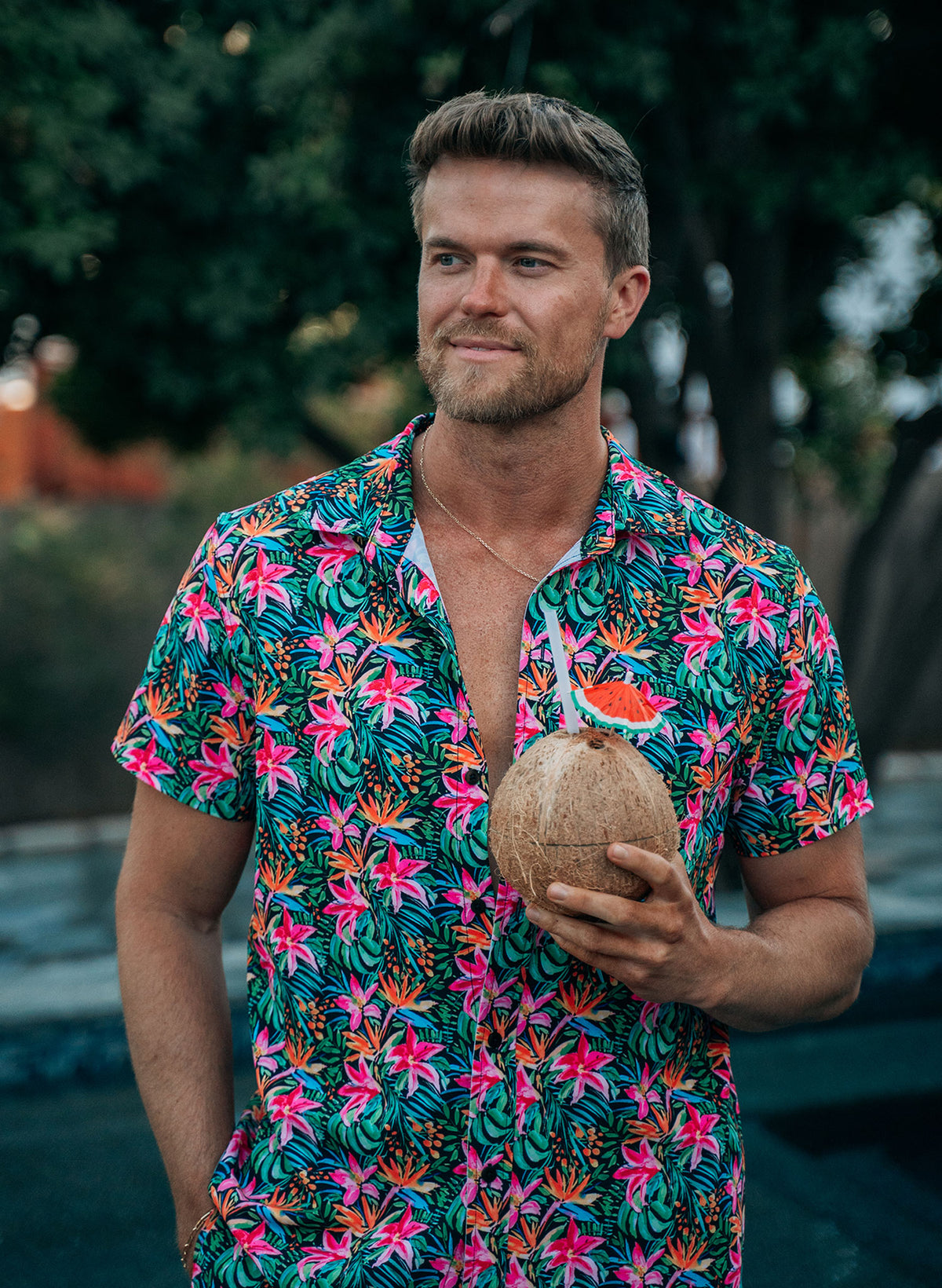 Men’s Island Bloom button-up shirt in tropical floral print, shown in front and back views. Styled open over matching swim trunks for a coordinated resort outfit. Features lightweight fabric, relaxed fit, and vibrant Island Bloom pattern. Perfect for beachwear, couples matching looks, and vacation-ready fashion by Salty Mermaid.