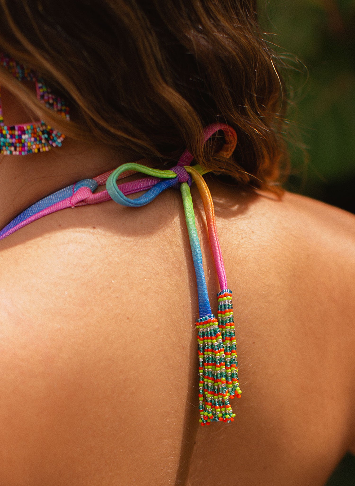 Salty Mermaid Rainbow Ursula Halter Bikini Top featuring shimmering metallic rainbow fabric, excellent support with structured cups, and hand-beaded tie ends. A bold, glittering halter swim top perfect for standout beach days and luxe resort style.