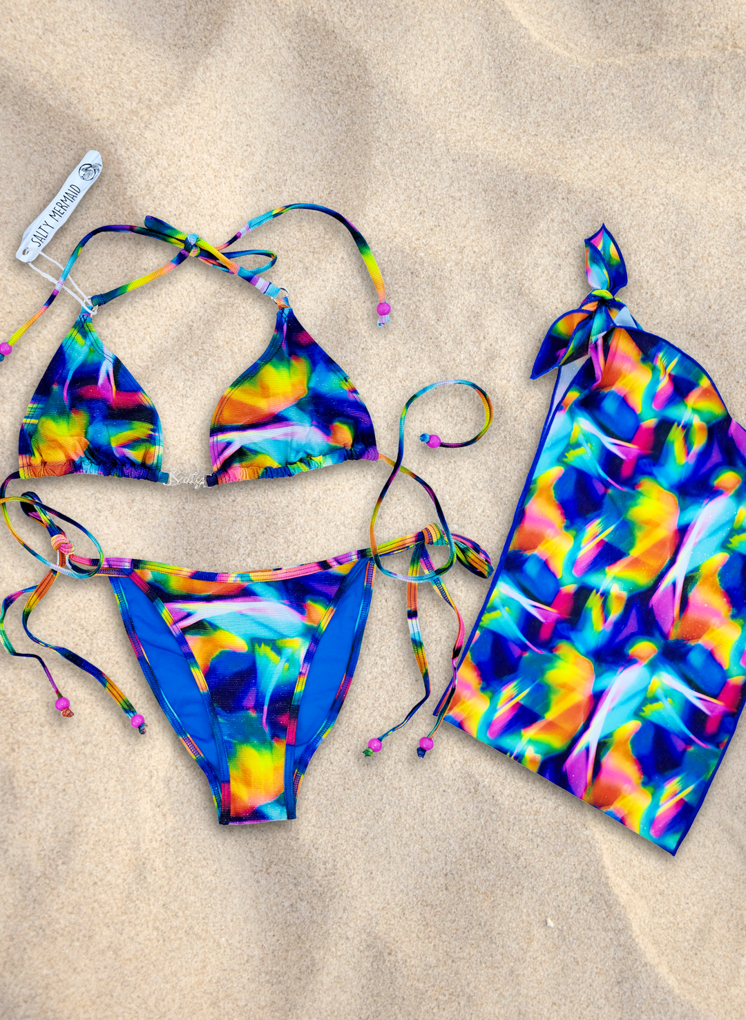 Multicolor bikini set with abstract rainbow print and side-tie bottoms and matching sarong by Salty Mermaid