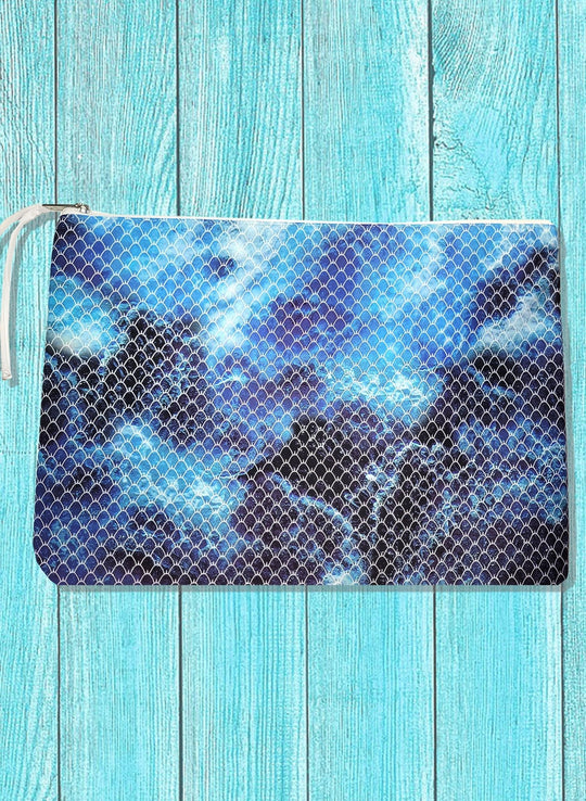 A tote bag with a zipper closure featuring an ocean ombre design in shades of blue and gray.