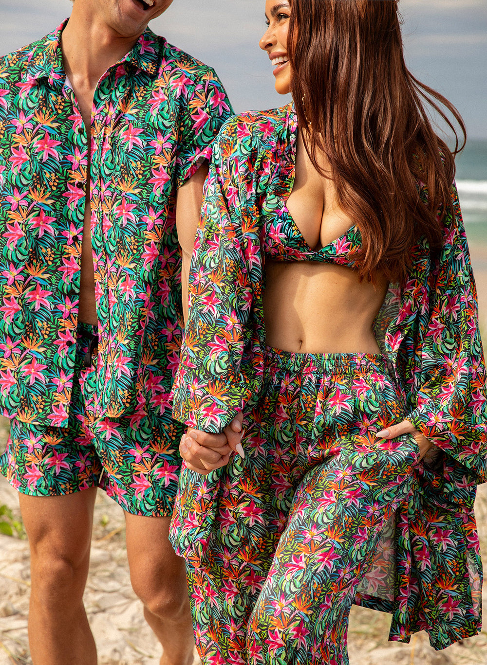Couple in Salty Mermaid Island Bloom tropical floral print couples matching swimwear set with bikini, cover up pants, shirt, and trunks