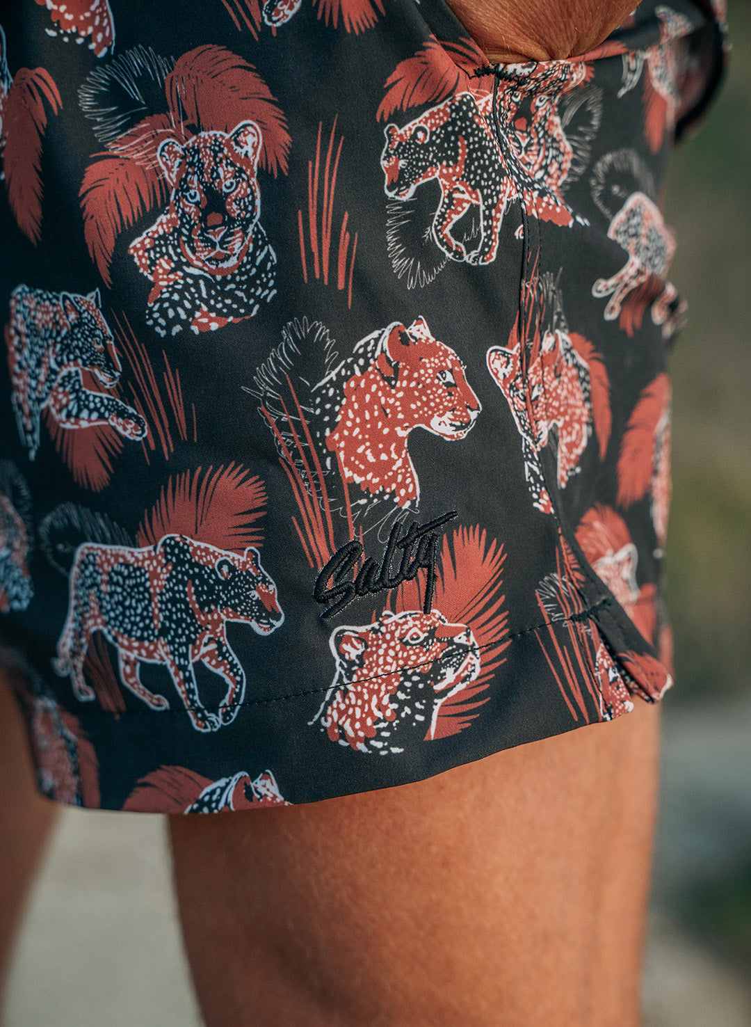 Salty Men's bathing suit with a leopard pattern. With embroidery branding and open slit sides.