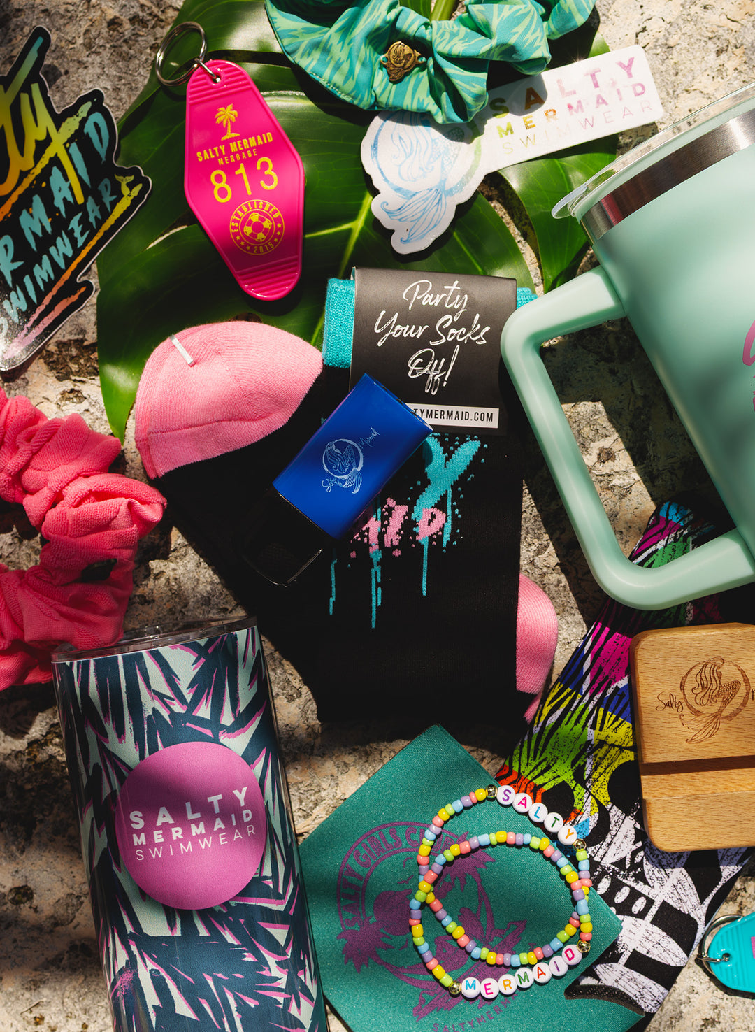 Salty Mermaid Mystery Box accessories with stickers, scrunchies, socks, tumblers, colorful friendship bracelets and keychains.