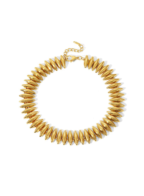 A gold-tone sahira caroline spiked collar necklace with elongated teardrop-shaped spikes and an adjustable chain clasp, shown on a plain white background.