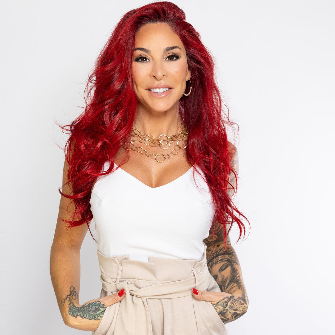 Professional headshot of Sarah Jon Porreca, founder and creator of Salty Mermaid, wearing a white top and beige pants against a light neutral background.