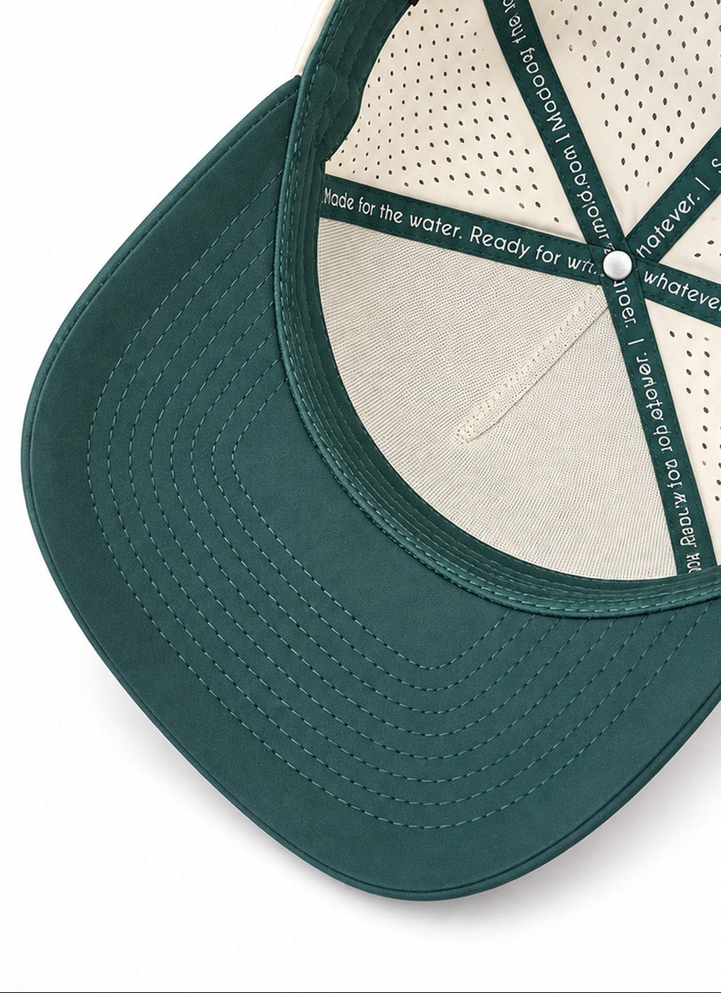 Interior of Salty Mermaid waterproof snapback hat showing cream perforated panels, green sweatband and custom branded seam tape.
