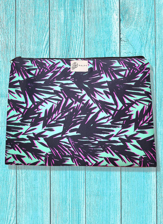 A multicolored spandex blend bikini bag with a zipper closure and a leaf pattern, displayed on a wooden background.